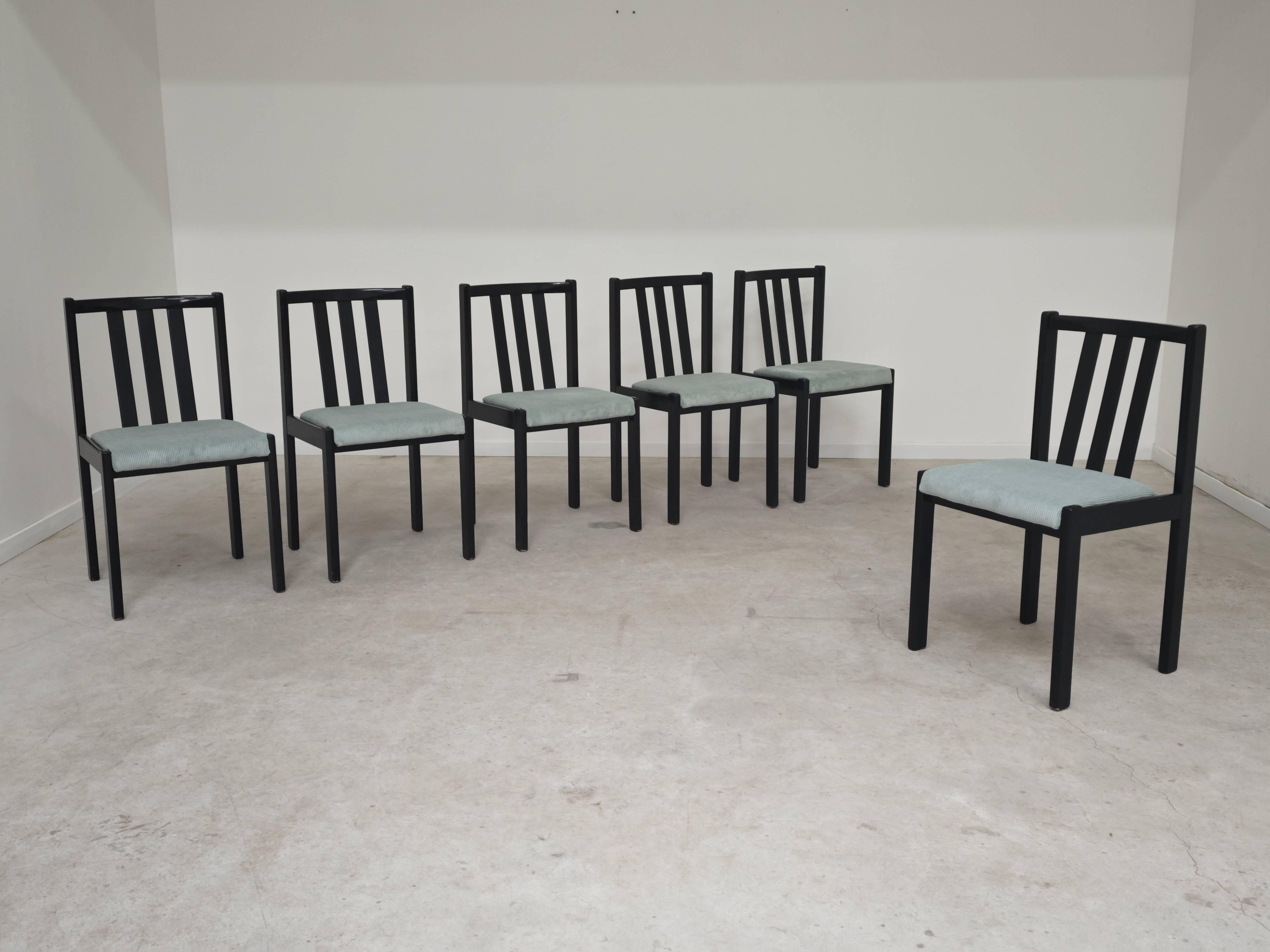 Set of 6 modernist black chairs with light blue-green ribbed fabric.