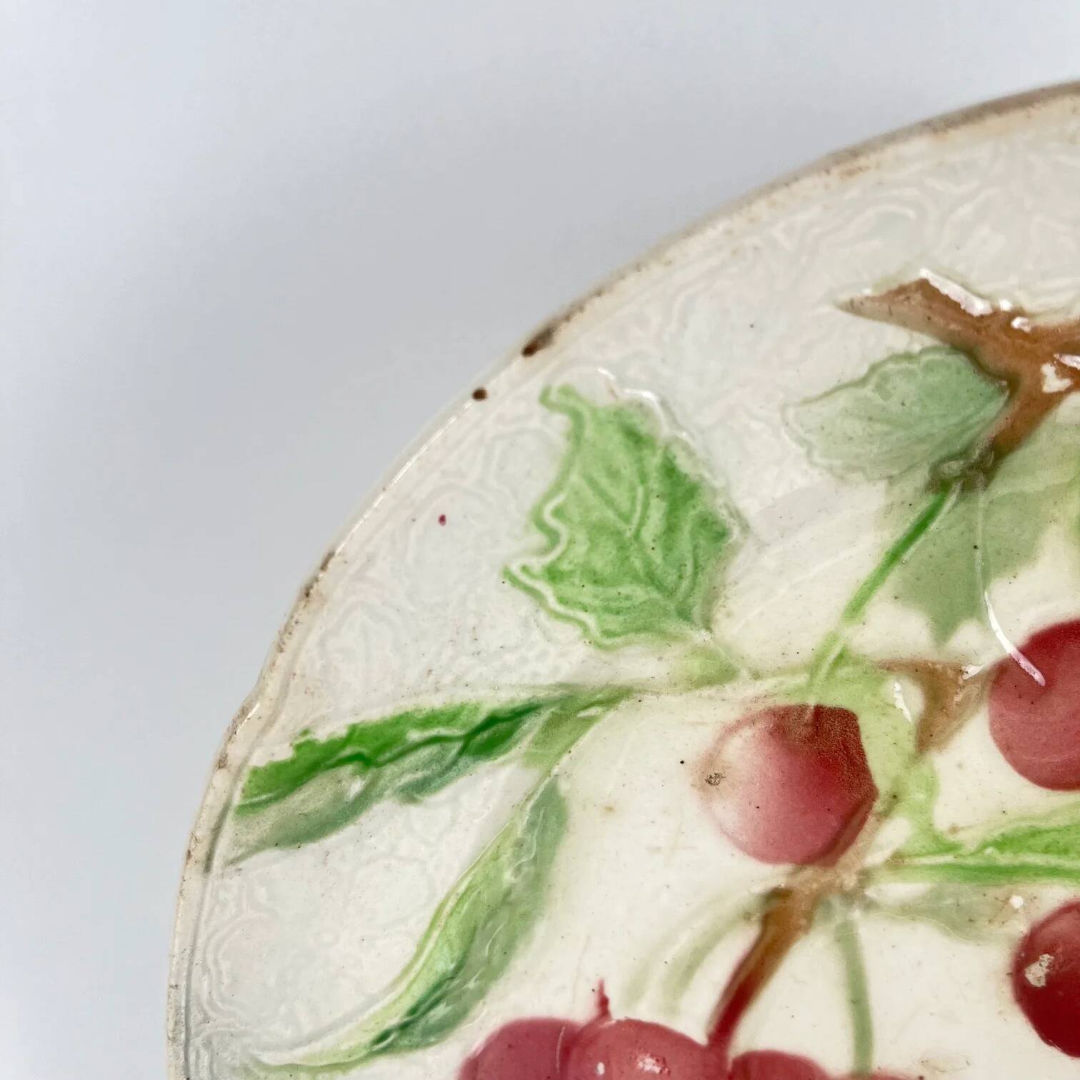 Set of 4 plates KG St Clément barbotine fruit (cherry, mirabelle, grape, pear), late 19th-early 20th century.