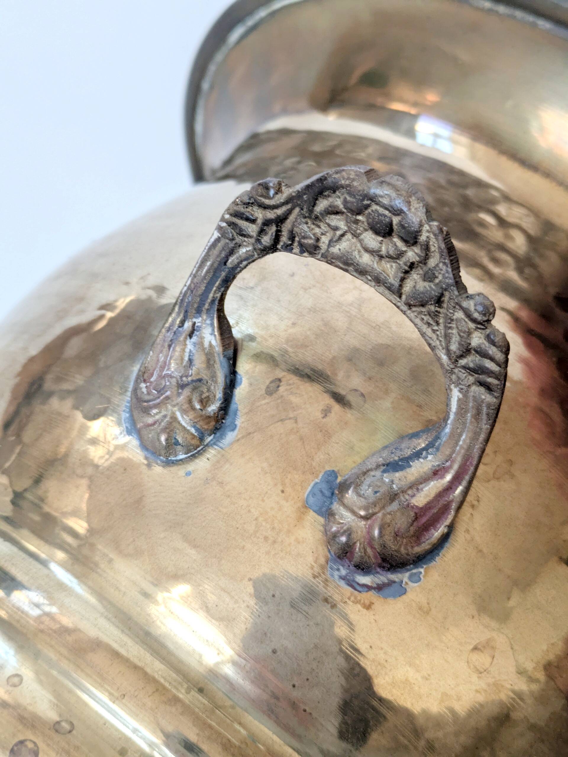 Vintage round cache-pot in hammered brass with decorative handles and patina.