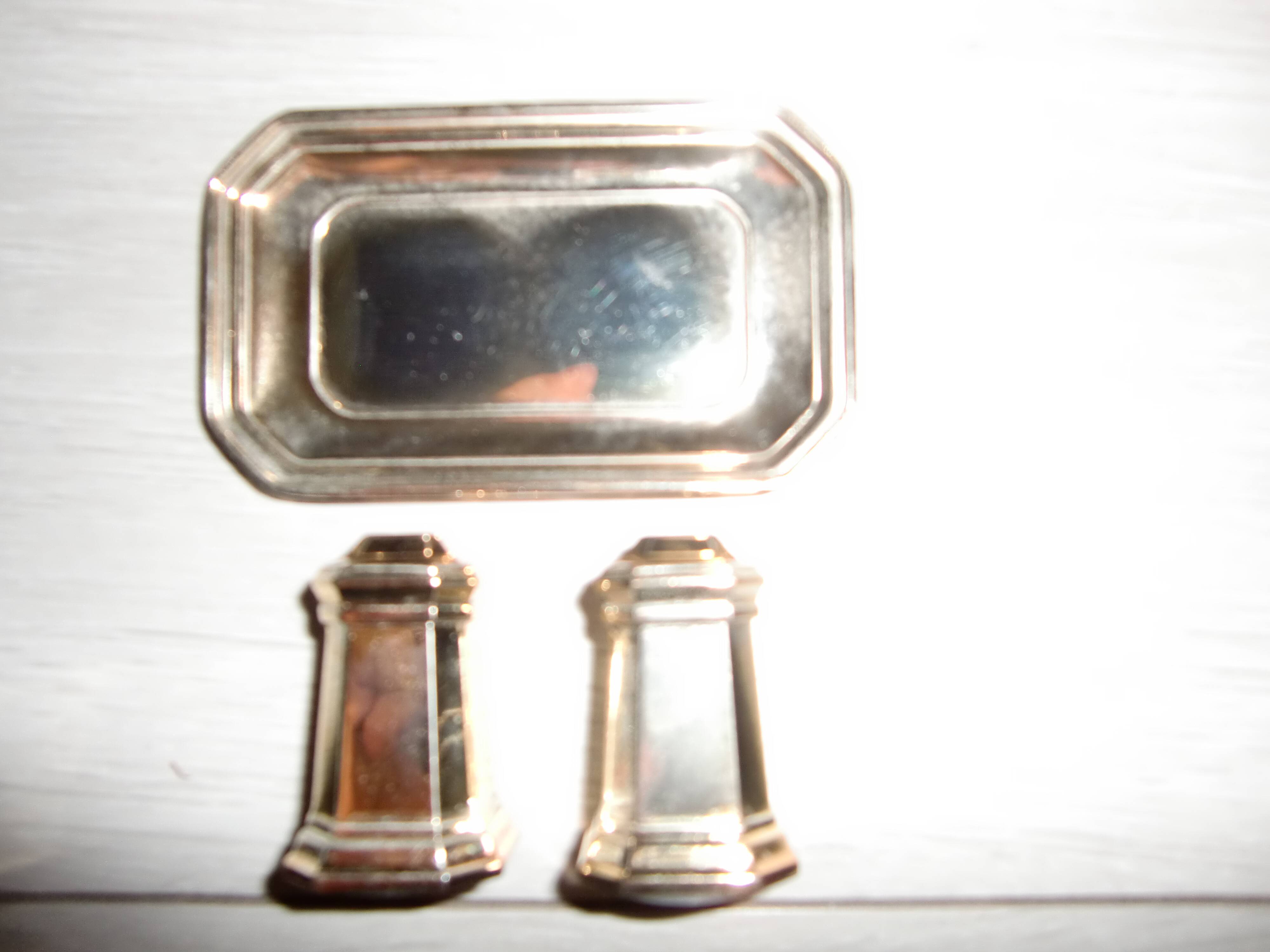 Silver-plated salt and pepper shakers presented on a small tray