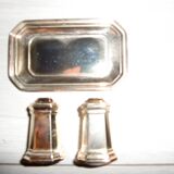 Silver-plated salt and pepper shakers presented on a small tray