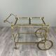 Rolling table cart in gilded brass with two glass shelves, 20th century.