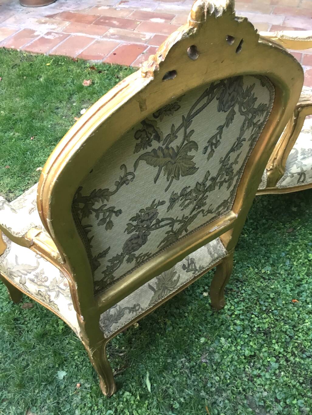 Pair of straight-backed armchairs, known as "queen's armchairs," in carved and gilded wood