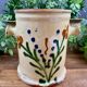 Antique ceramic pot with hand-painted floral decoration.