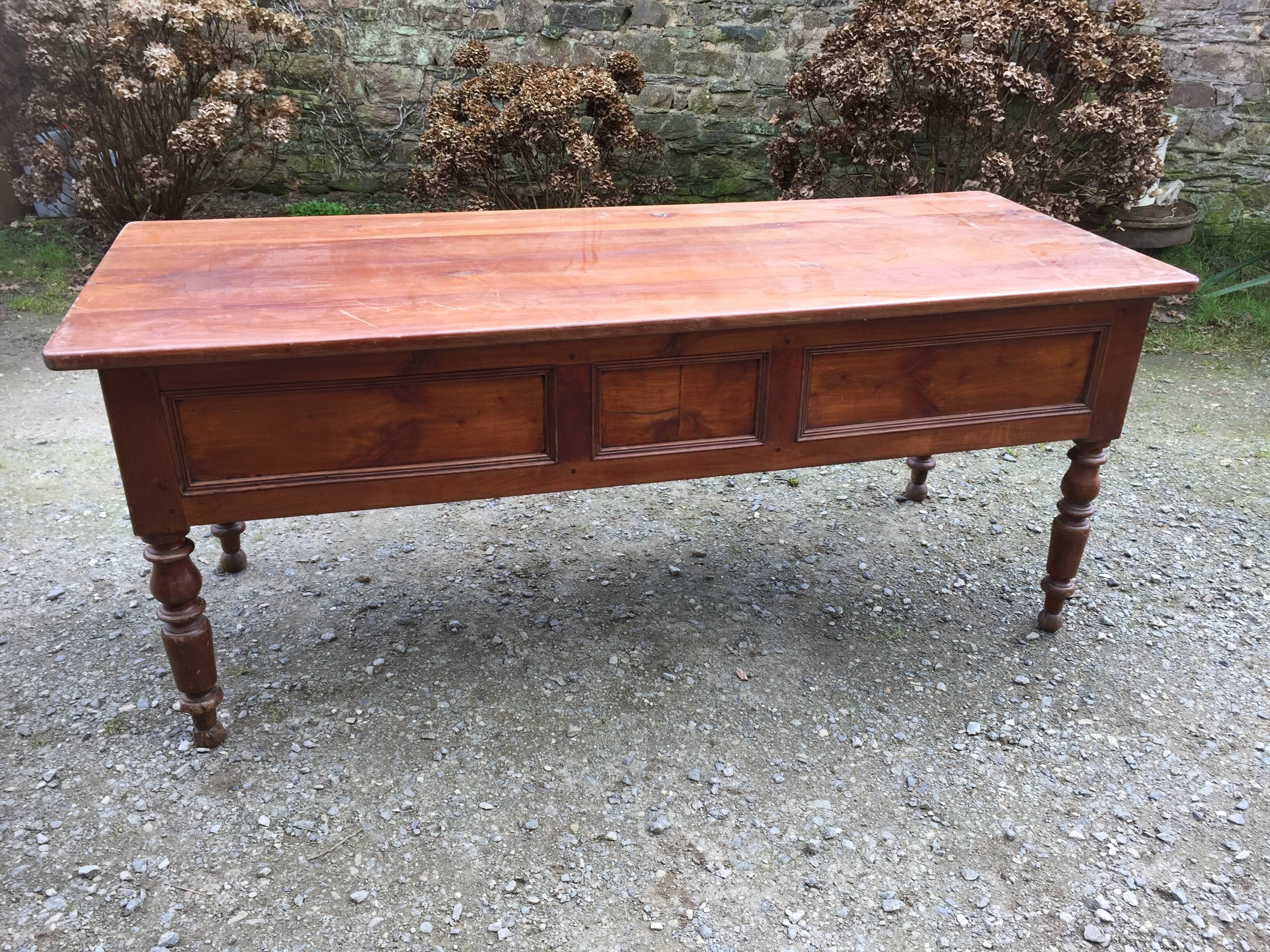 Old farmhouse table with cherry and chestnut panels with 3 drawers.