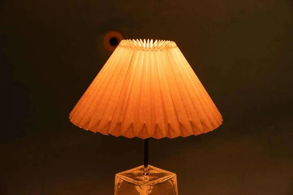 Minimalist glass table lamp from the 80s with a pleated shade.