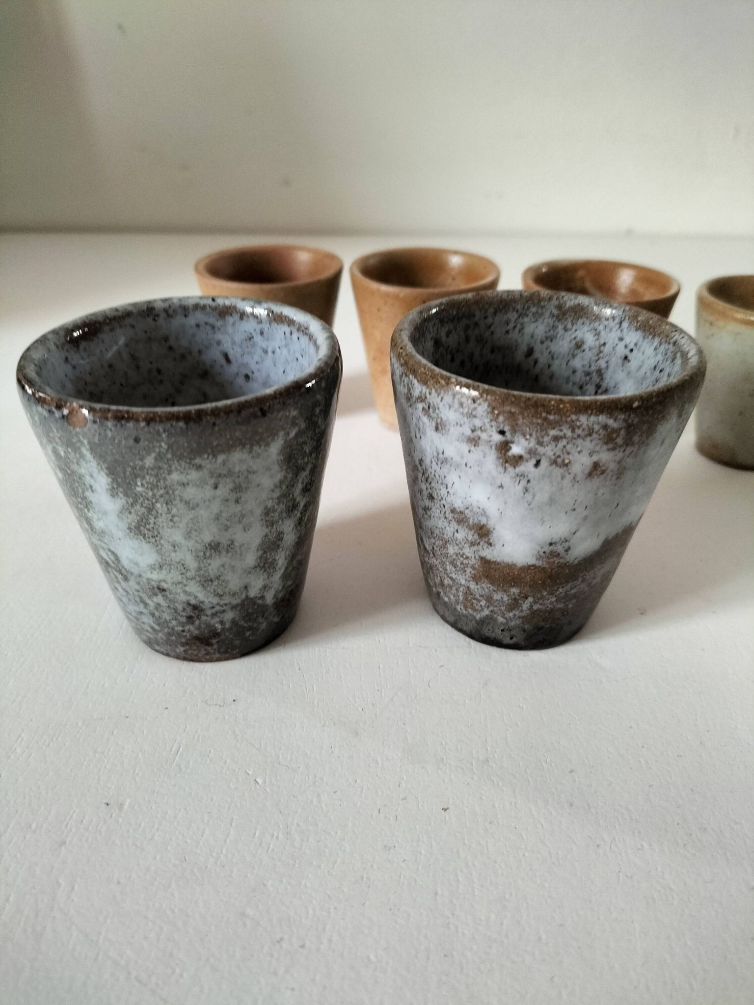 Set of 8 stoneware cups and a mug, shades of beige.
