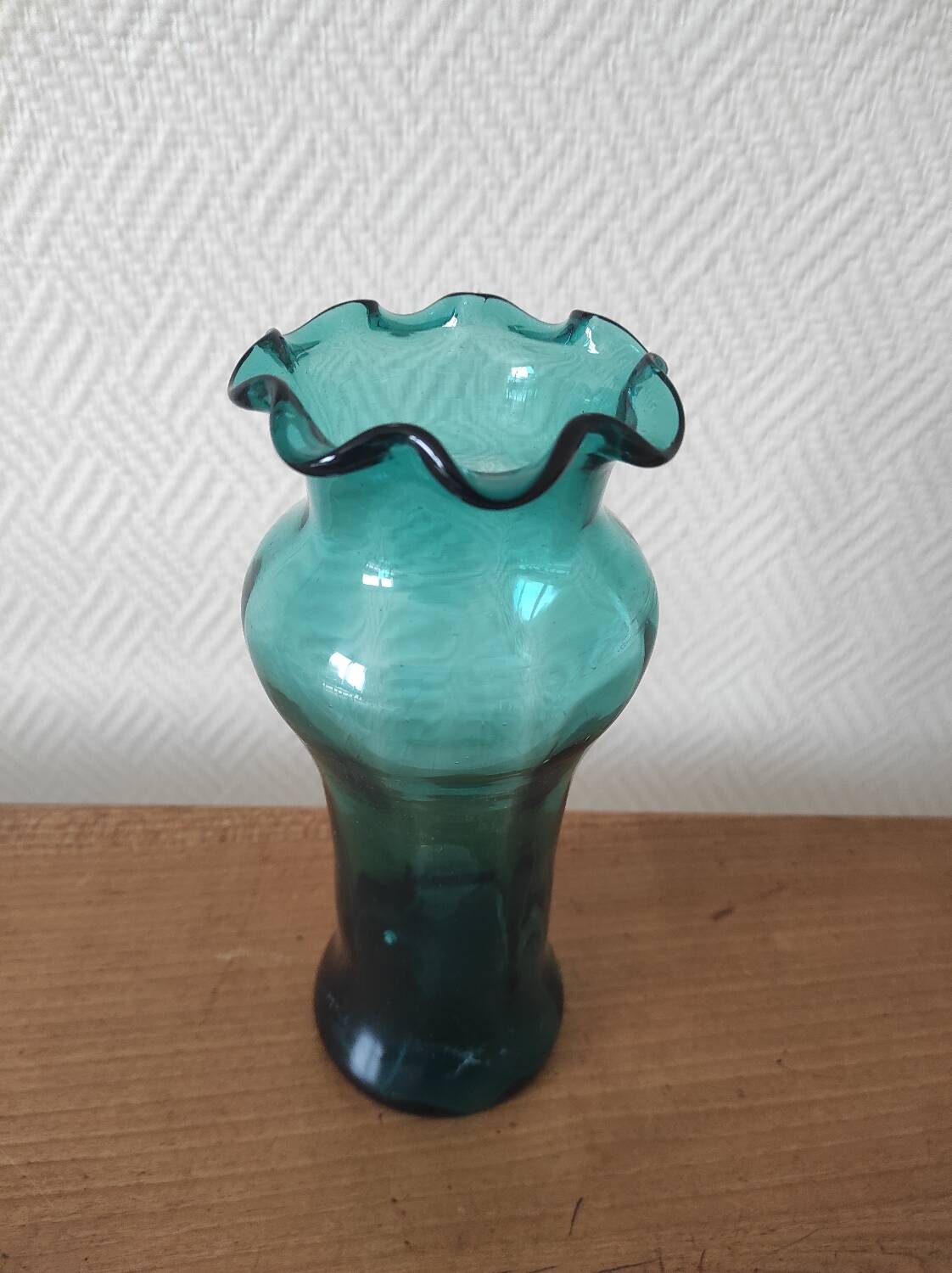 Blown glass vase with a flared neck and wavy rim.