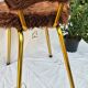 Vintage shaggy chair in faux fur with golden metal legs.