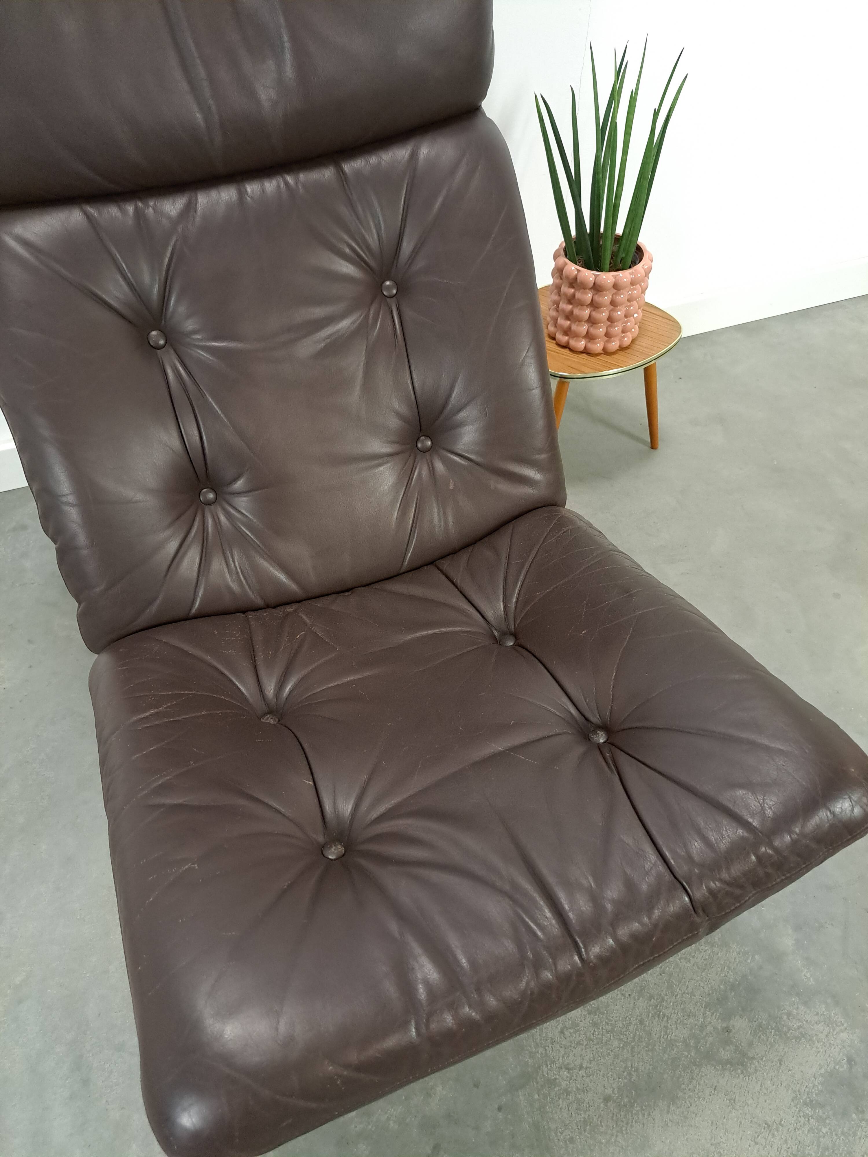 Bruin leren fauteuil met houten onderstel