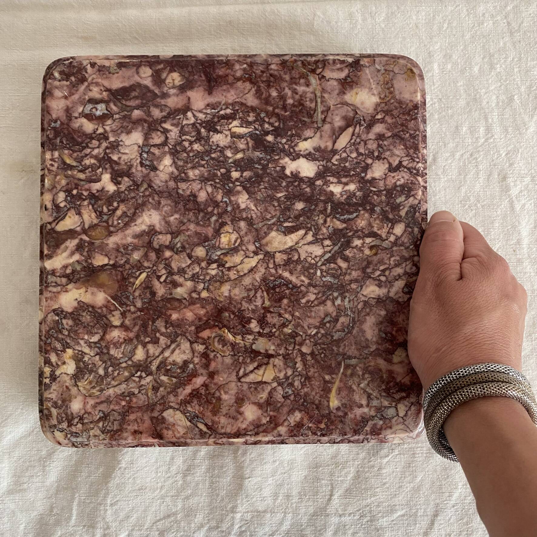Pink marble trivet with brass ball feet.