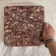 Pink marble trivet with brass ball feet.