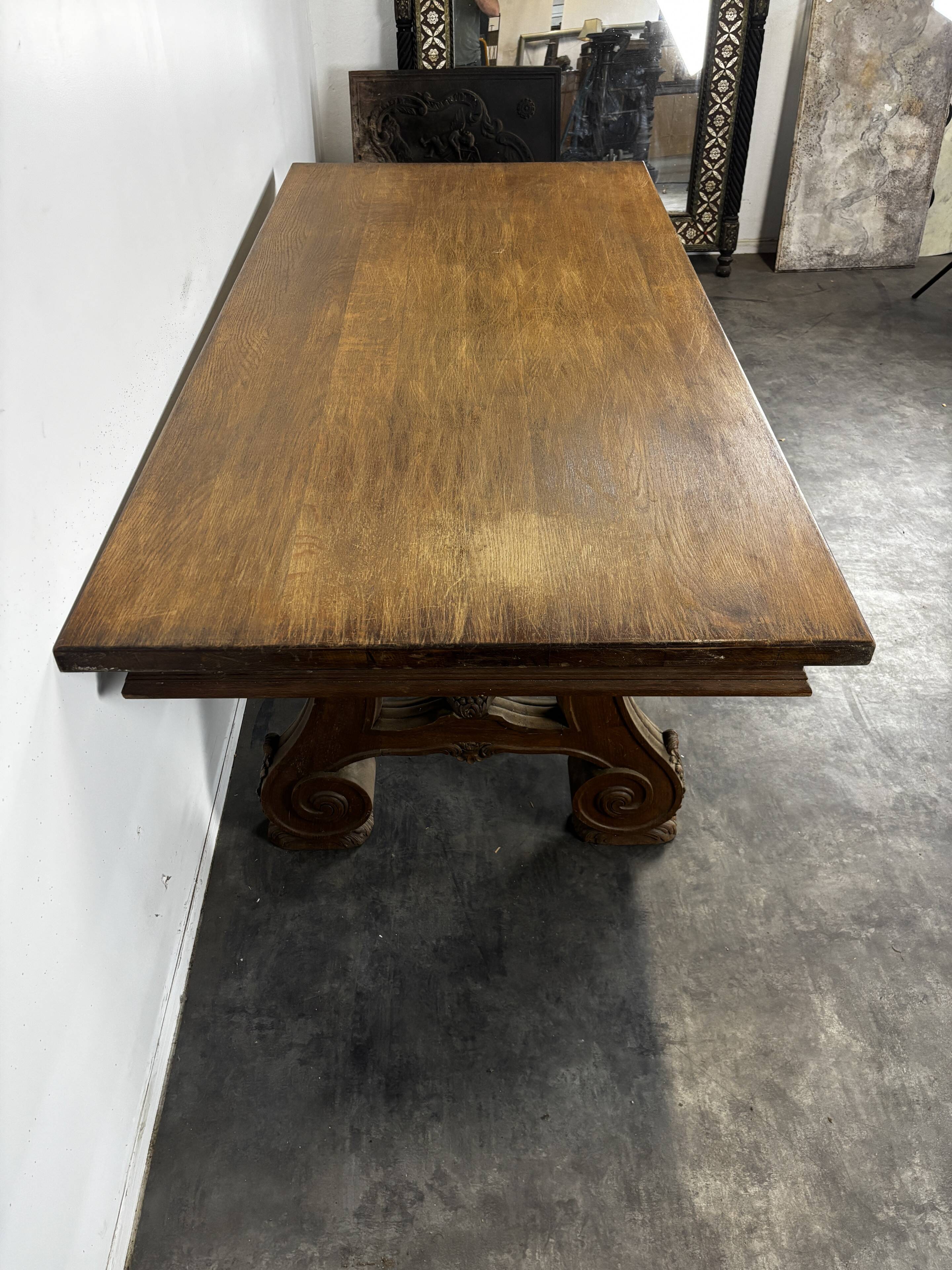 Renaissance-style oak dining table with lyre legs.
