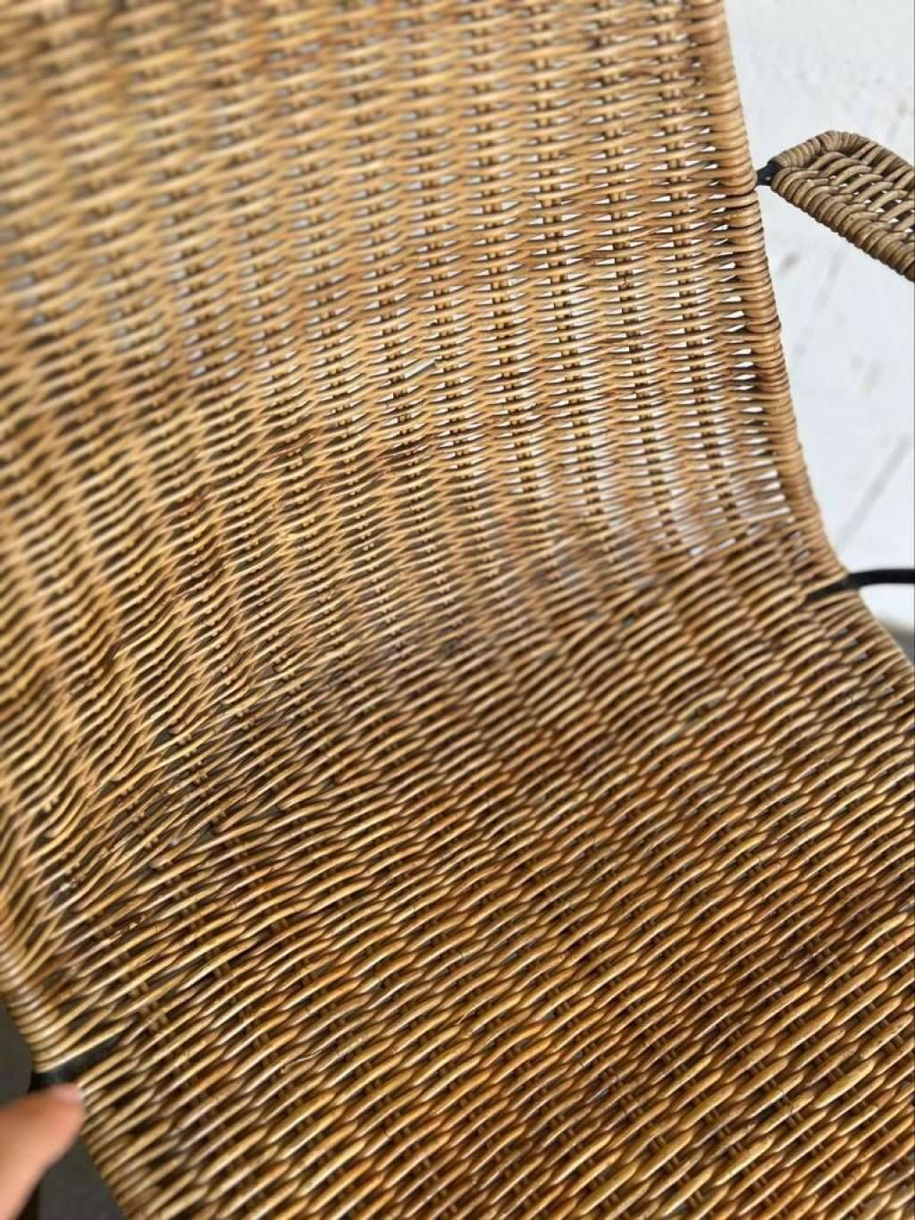 Vintage wicker chair with black steel frame and armrests