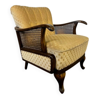 Vintage wooden armchair with rattan weaving.