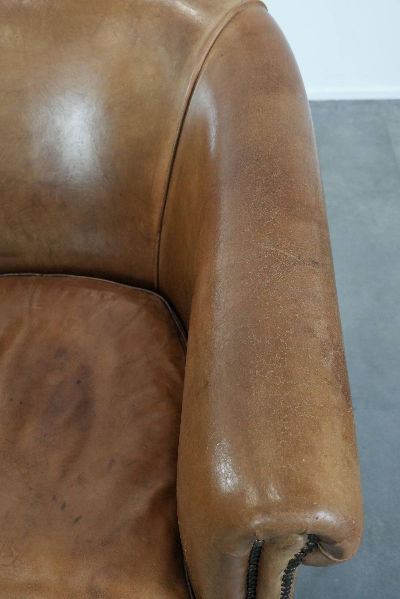 Characterful club chair made of sheepskin leather with light cognac colours