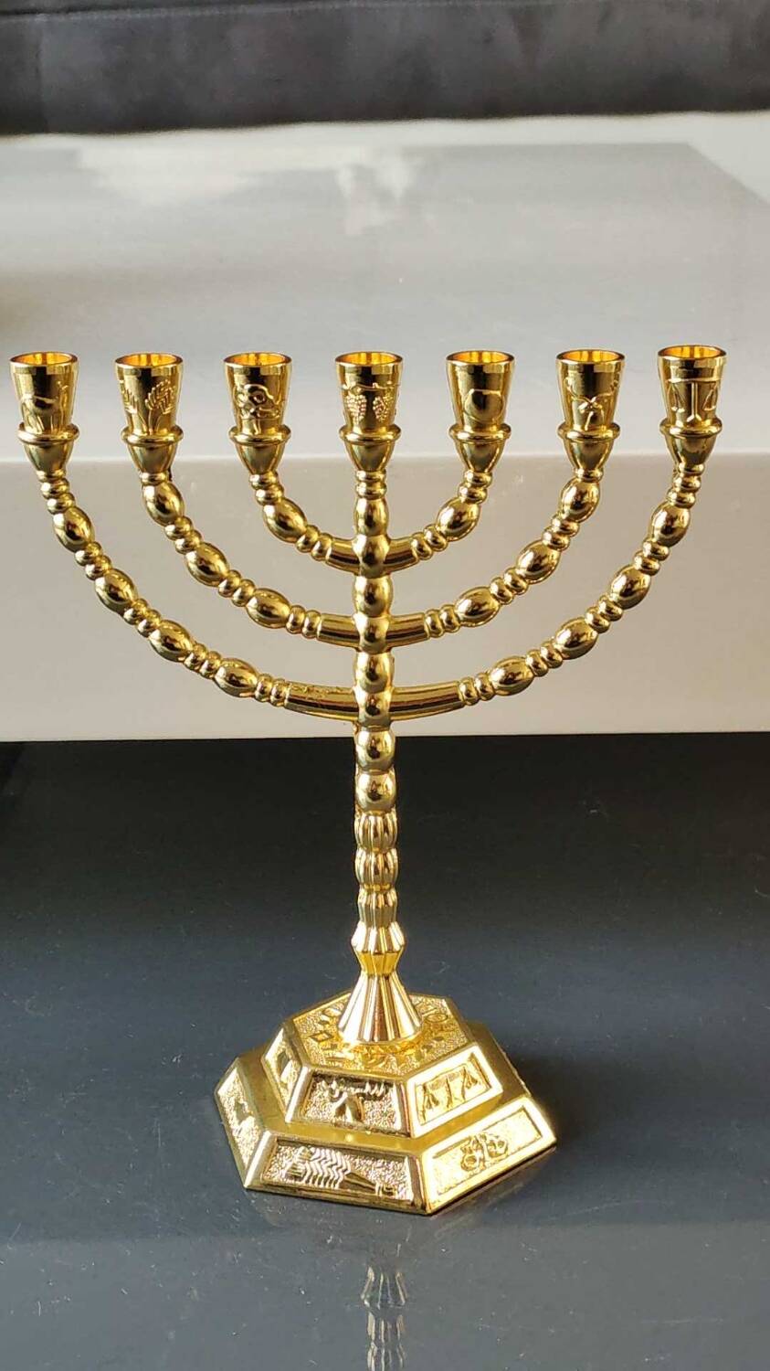 Menorah/Jewish/Hebrew candlestick with 7 arms of light. Engraved with the symbols of the 12 tribes of Israel/Holyland inscription. In gold metal. Size 20 x 16 cm