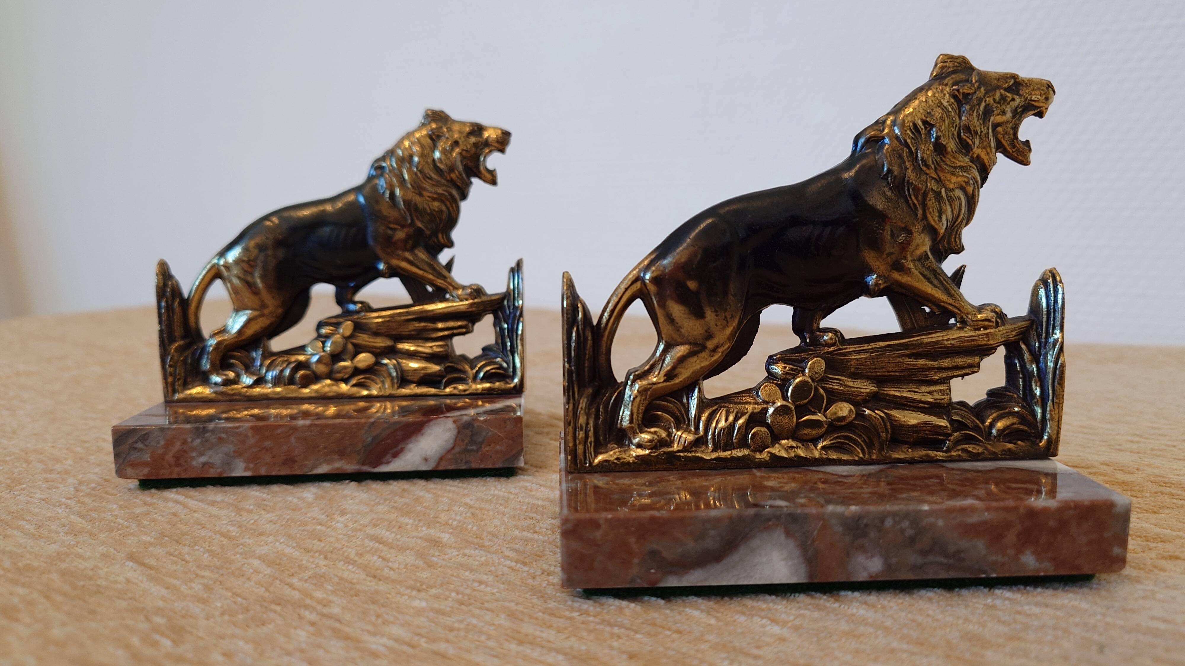 Small roaring lion bookends in patinated metal on a marble base.