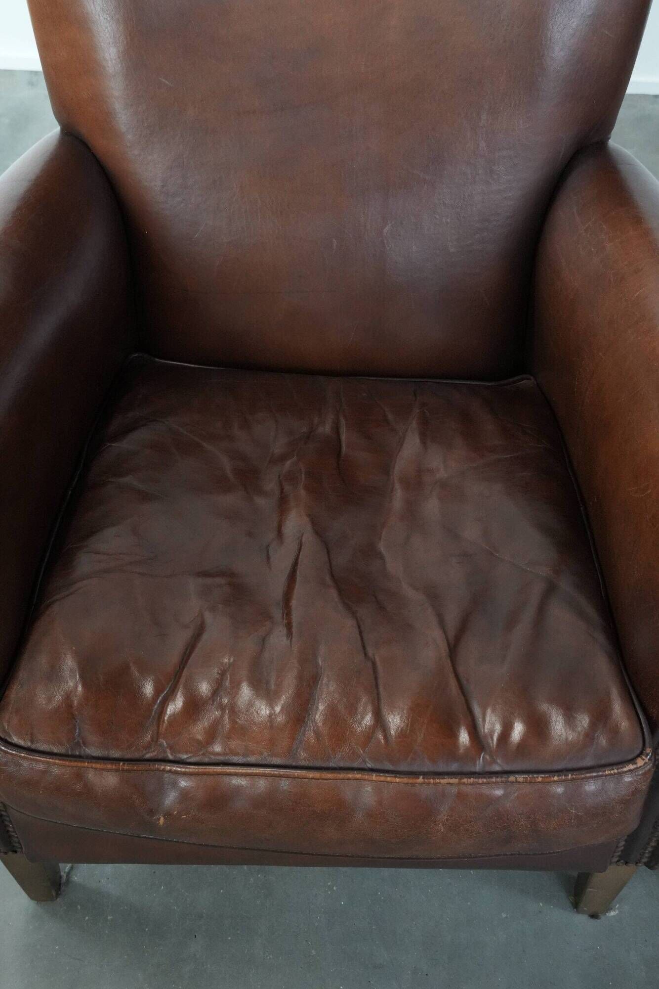 Ensemble de deux fauteuils en cuir de mouton vintage au caractère marqué.