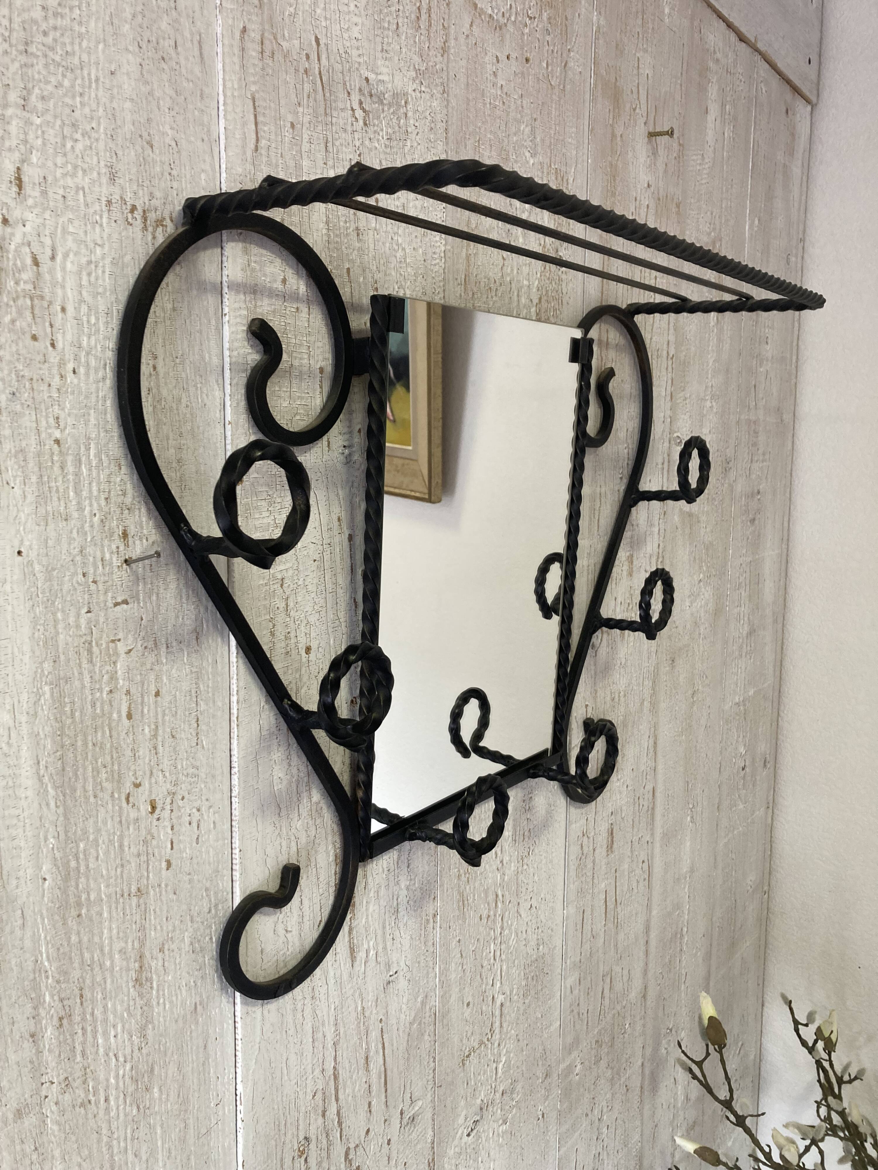 Wall-mounted coat rack with its mirror.