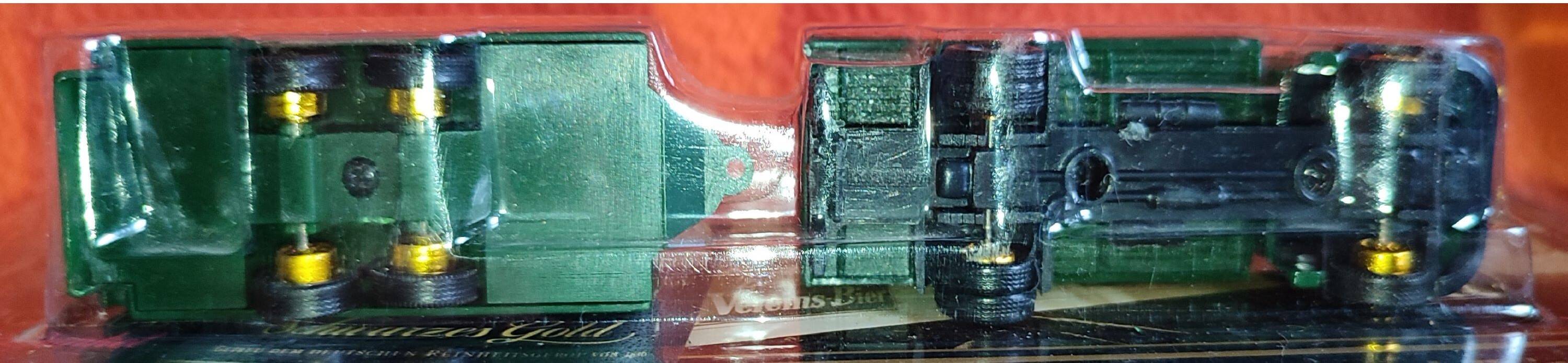 Mercedes flatbed containing drums pulling 1 trailer carrying 1 covered vehicle