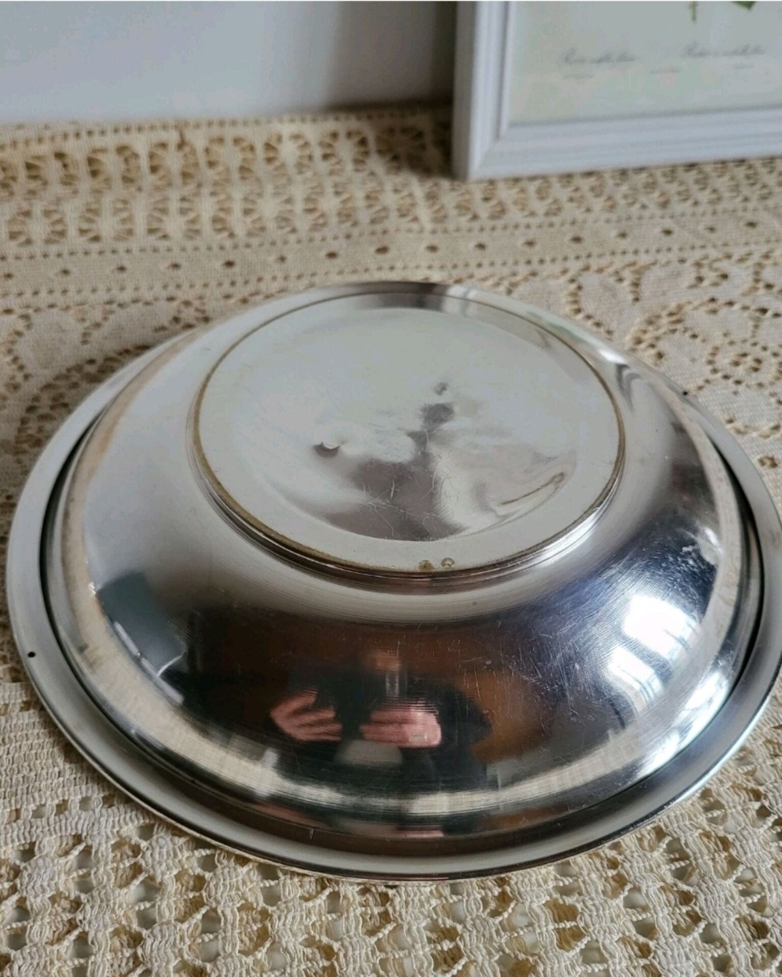 Shallow round metal plate with pearl row decoration.