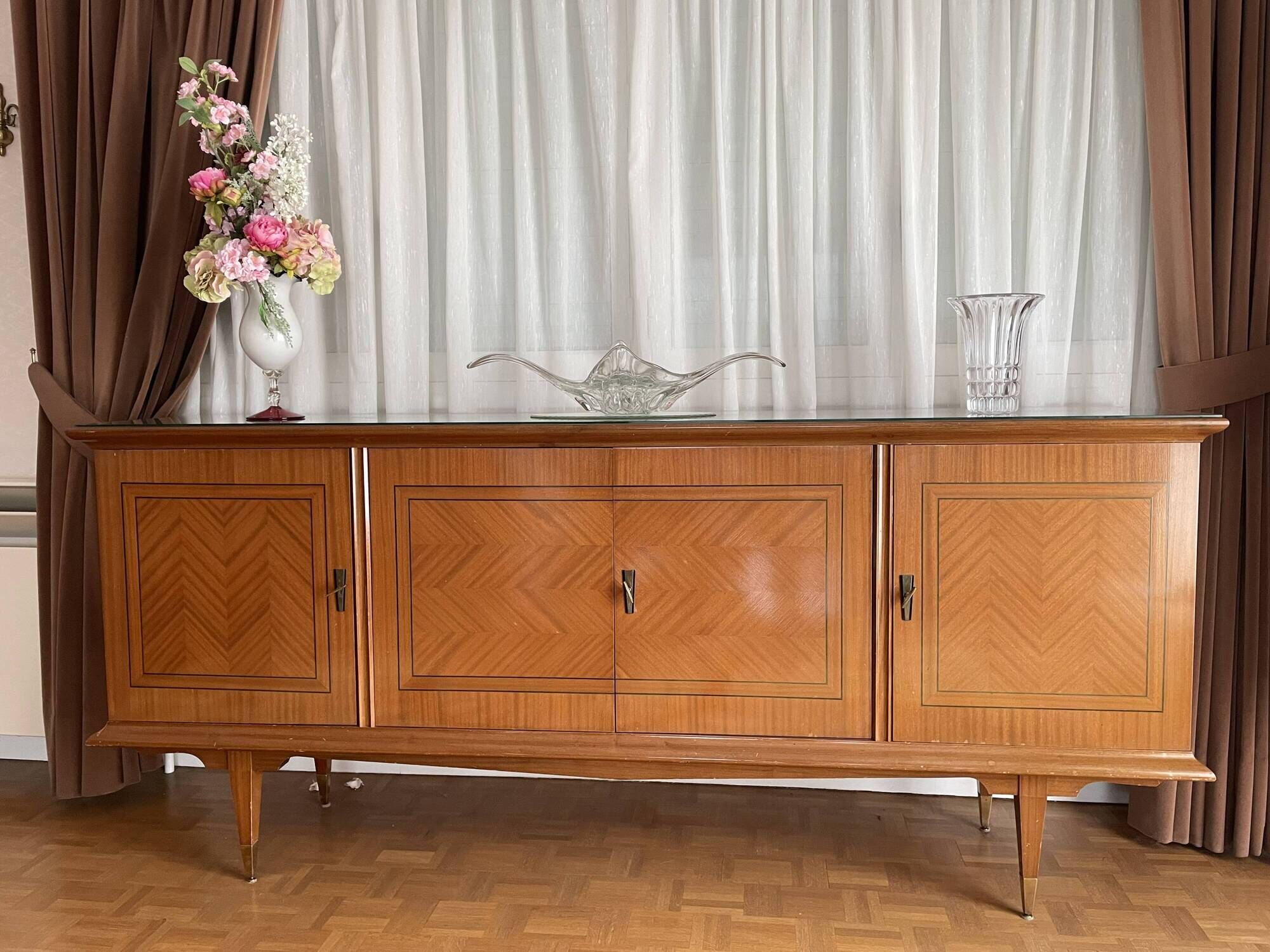 Vintage 4-door buffet with wood veneer and glass top.