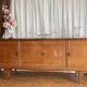 Vintage 4-door buffet with wood veneer and glass top.