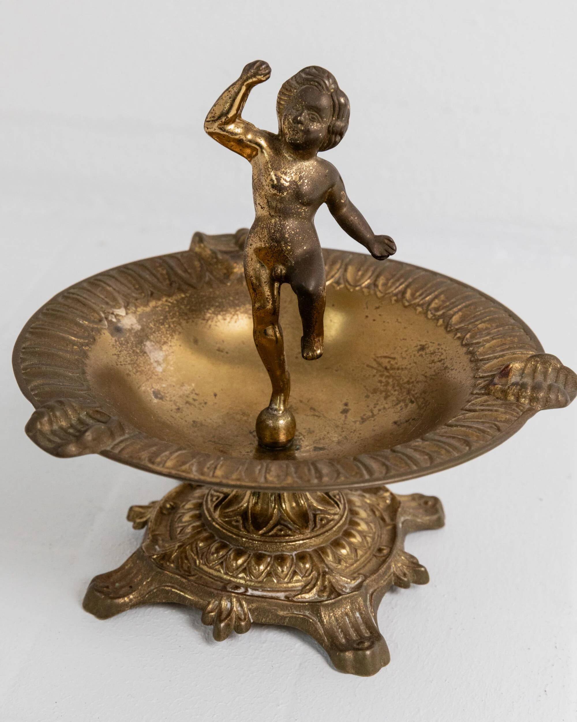 Vintage brass ashtray from the 1940s with a nude boy figurine on a footed base.