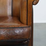 Unique vintage cognac-coloured leather club armchair with black piping