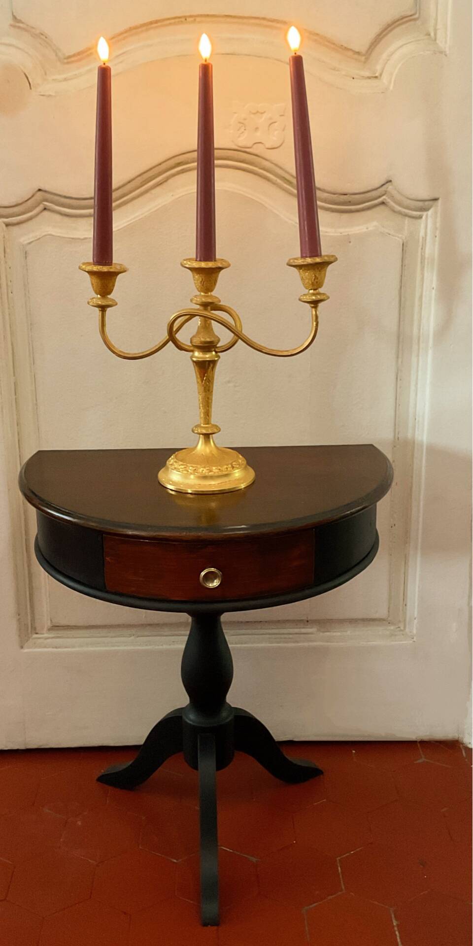 Antique half-moon side table in wood and black.