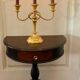 Antique half-moon side table in wood and black.