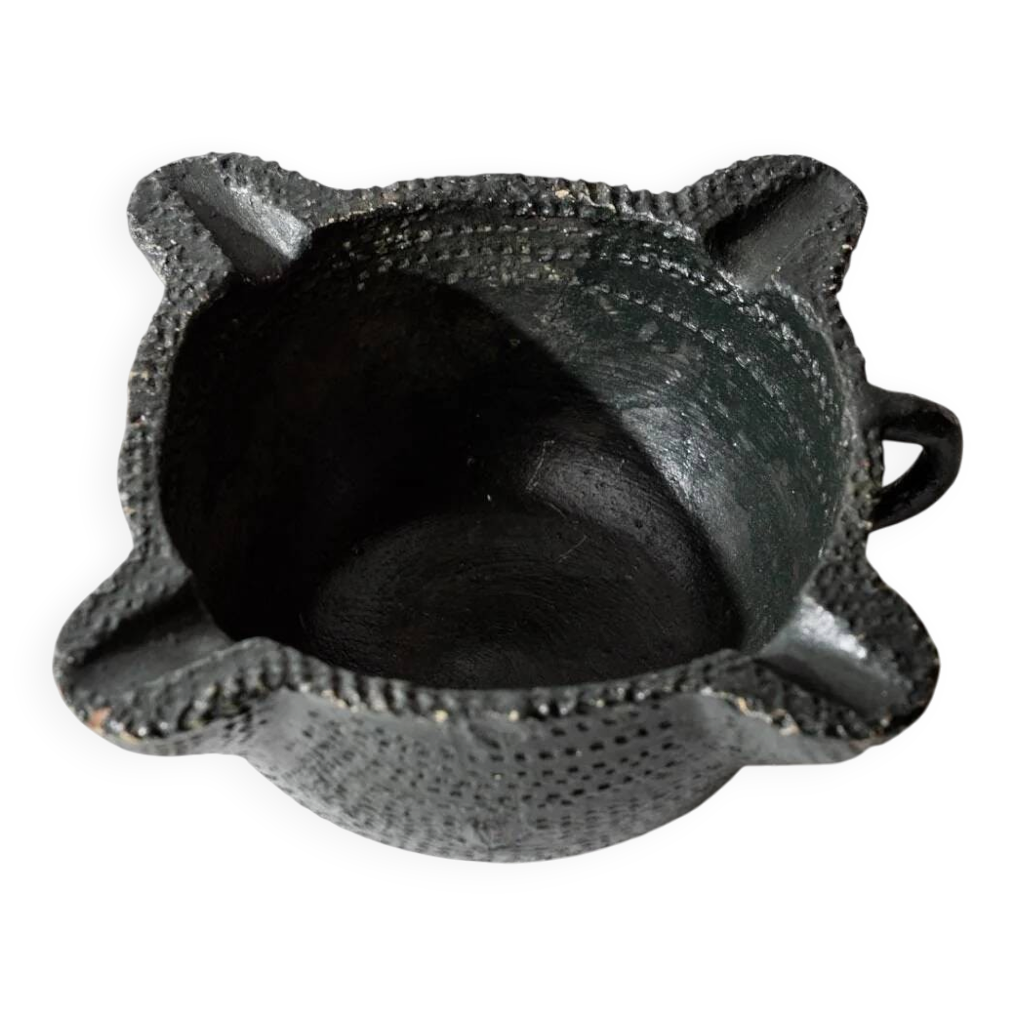 Vintage ceramic ashtray from the 1960s, black, hand-sculpted texture, organic shape.