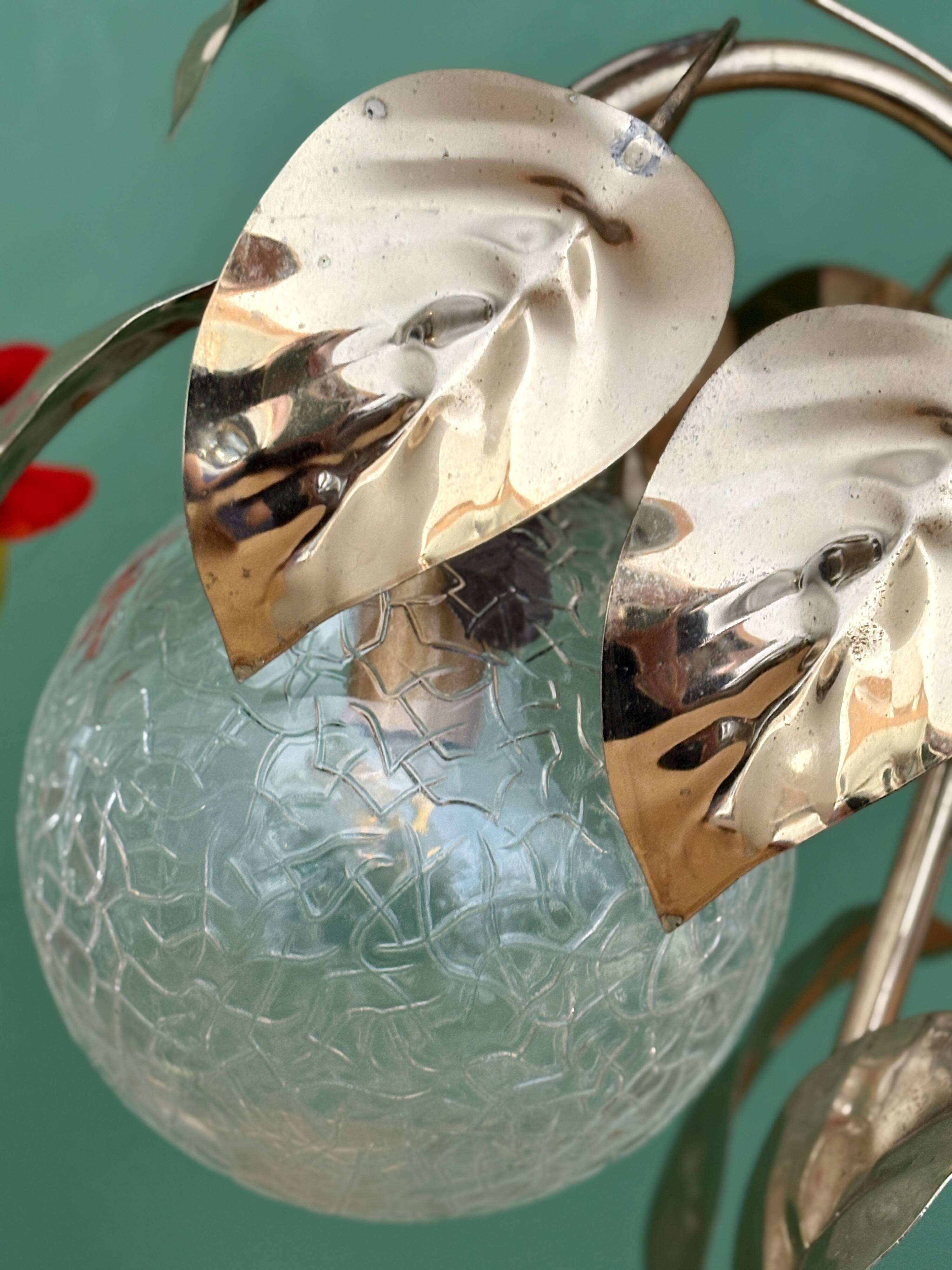 Vintage lamp with brass leaf design and transparent glass globe.