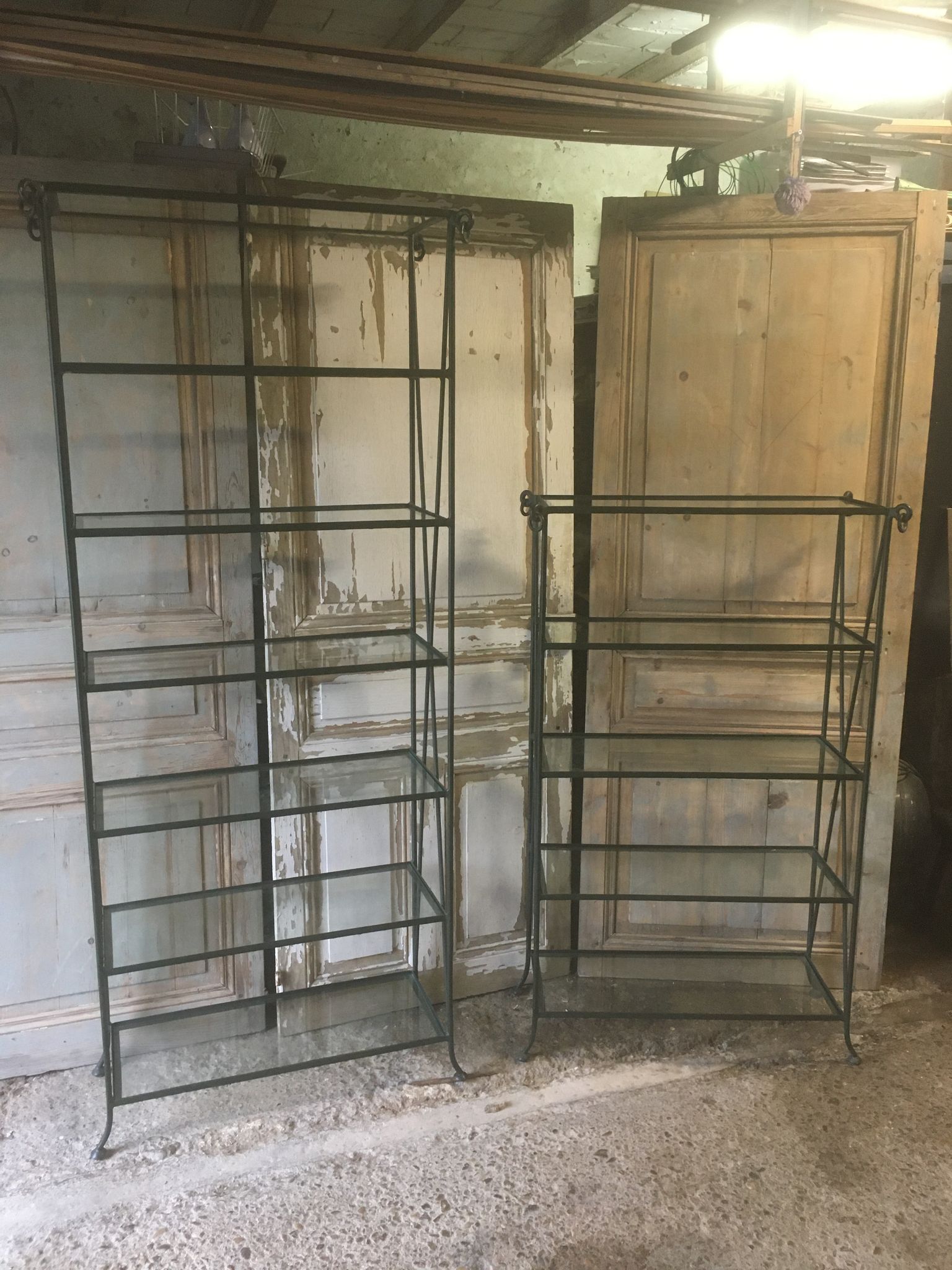 Pair of wrought iron and glass bookshelf shelves.