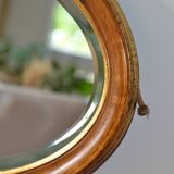 Old oval beveled wooden mirror, partly gilded and carved