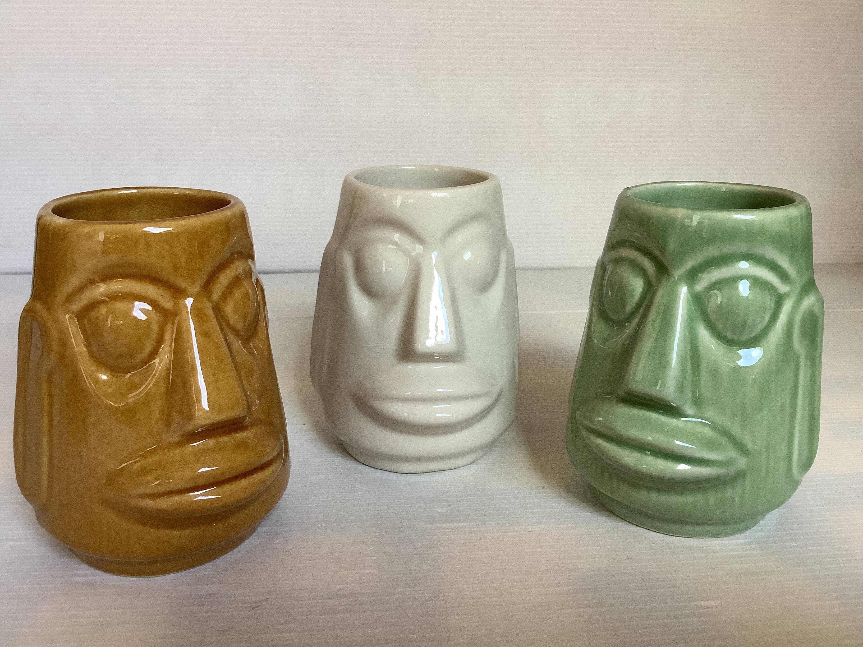 Set of three small Moai-style head vases.
