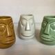 Set of three small Moai-style head vases.
