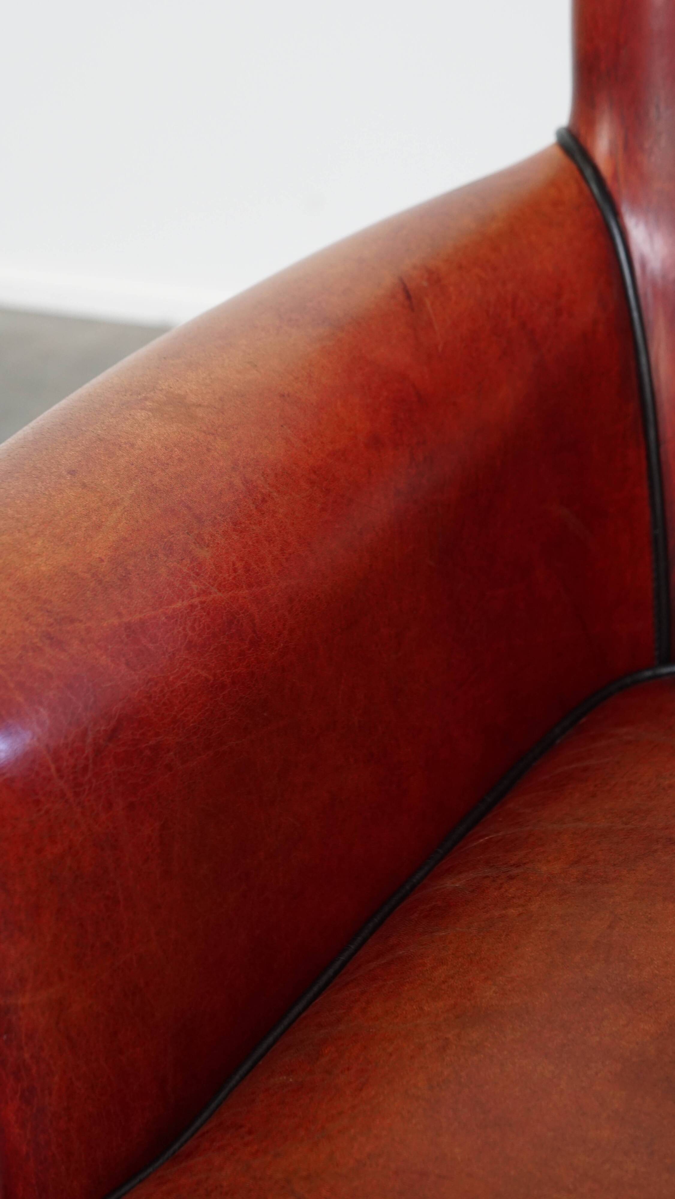 Armchair made of sheepskin leather in a red/brown color
