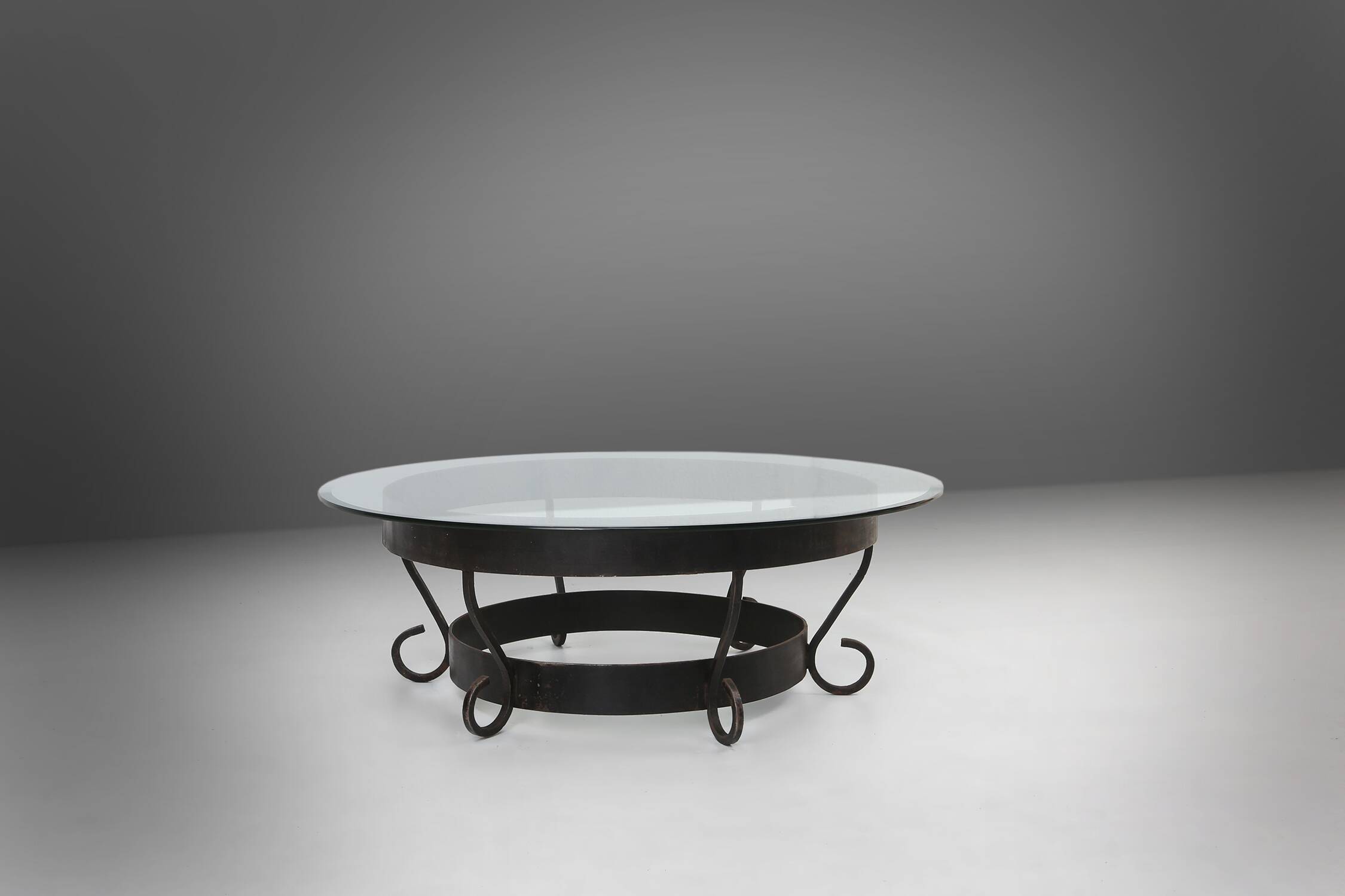 Rustic round coffee table with wrought iron base and glass top, France, 1930s