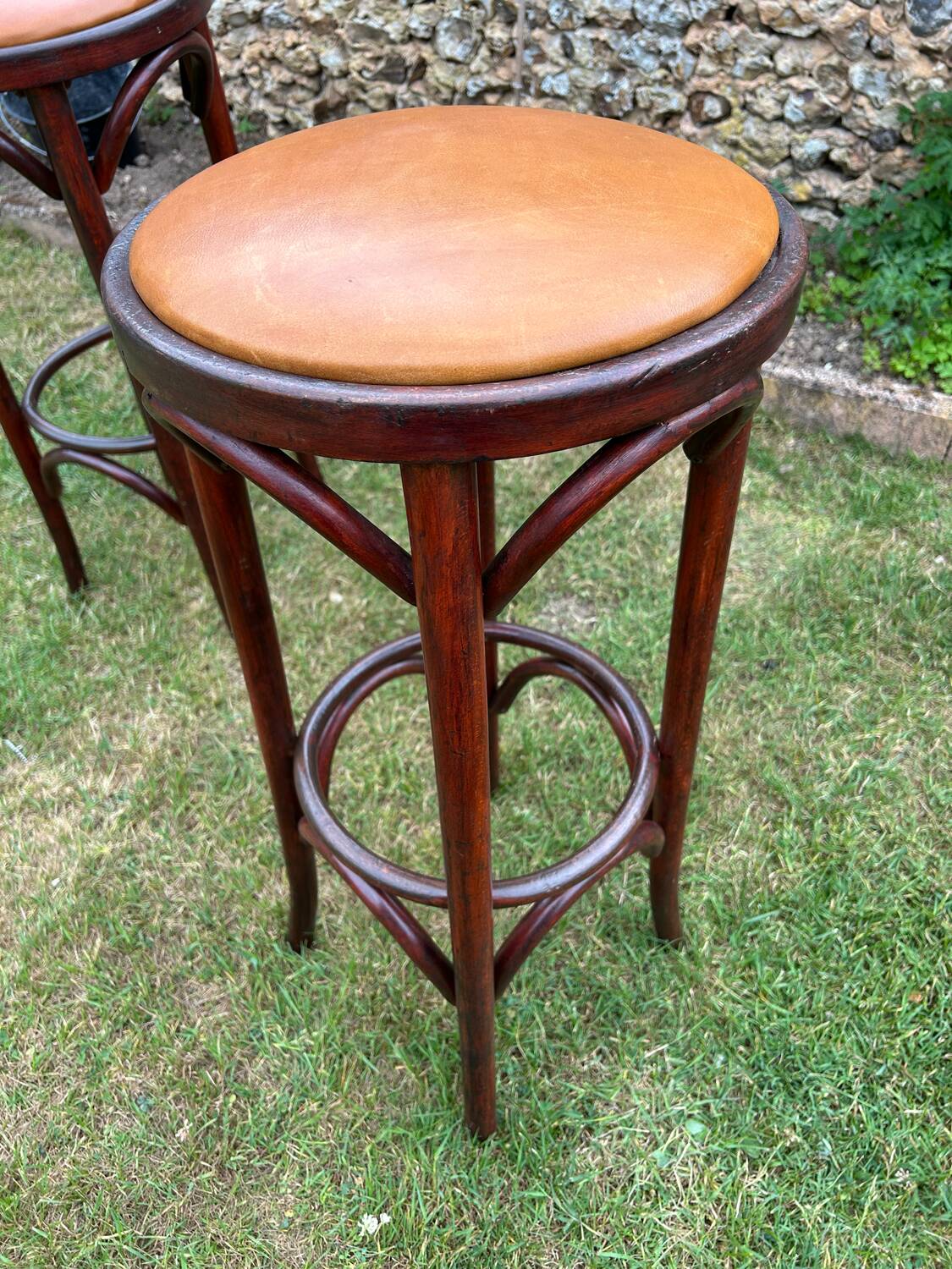 Pair of curved wooden bistro stools with leather seats