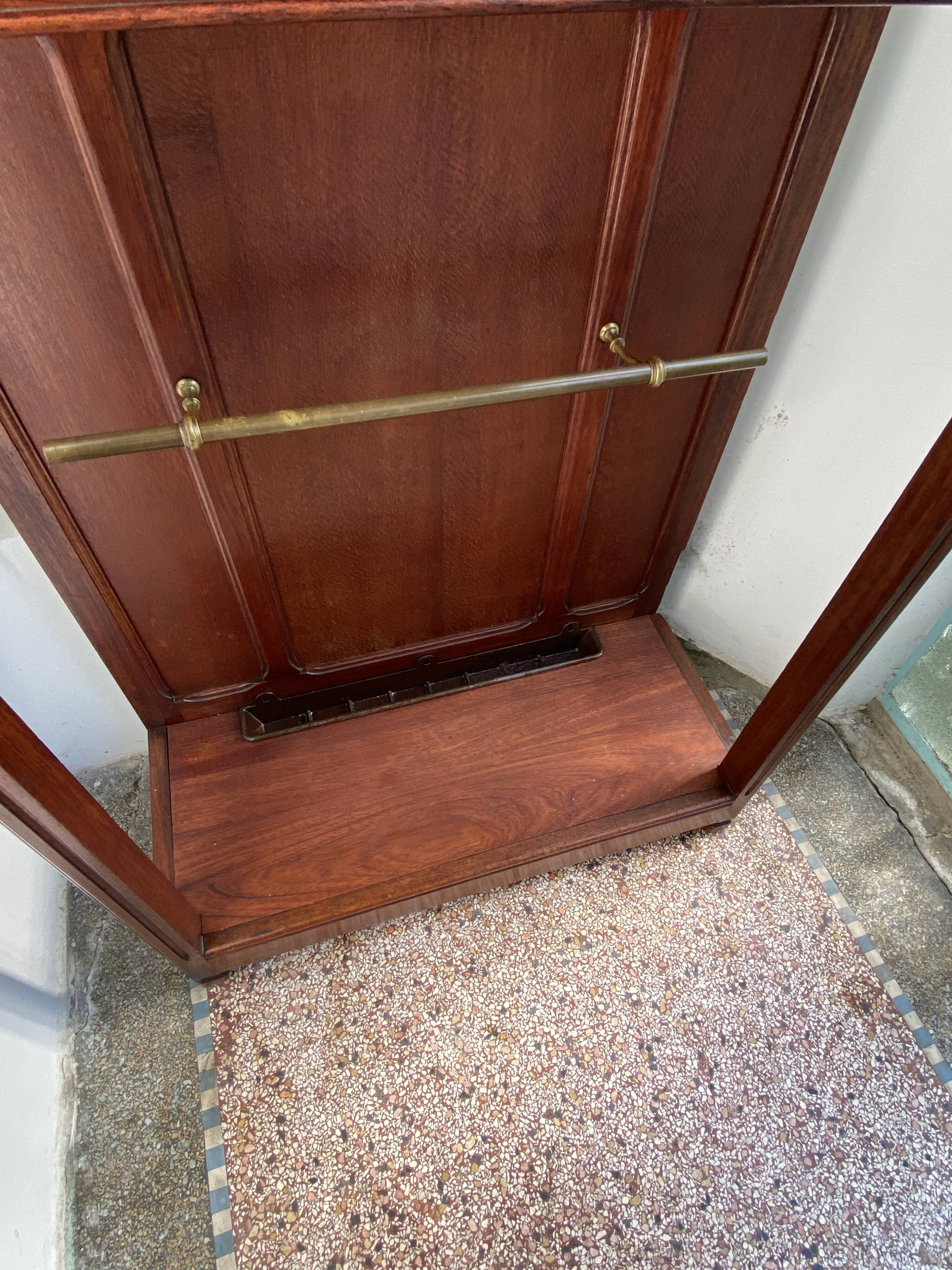 Antique wooden coat rack with mirror and shelf.