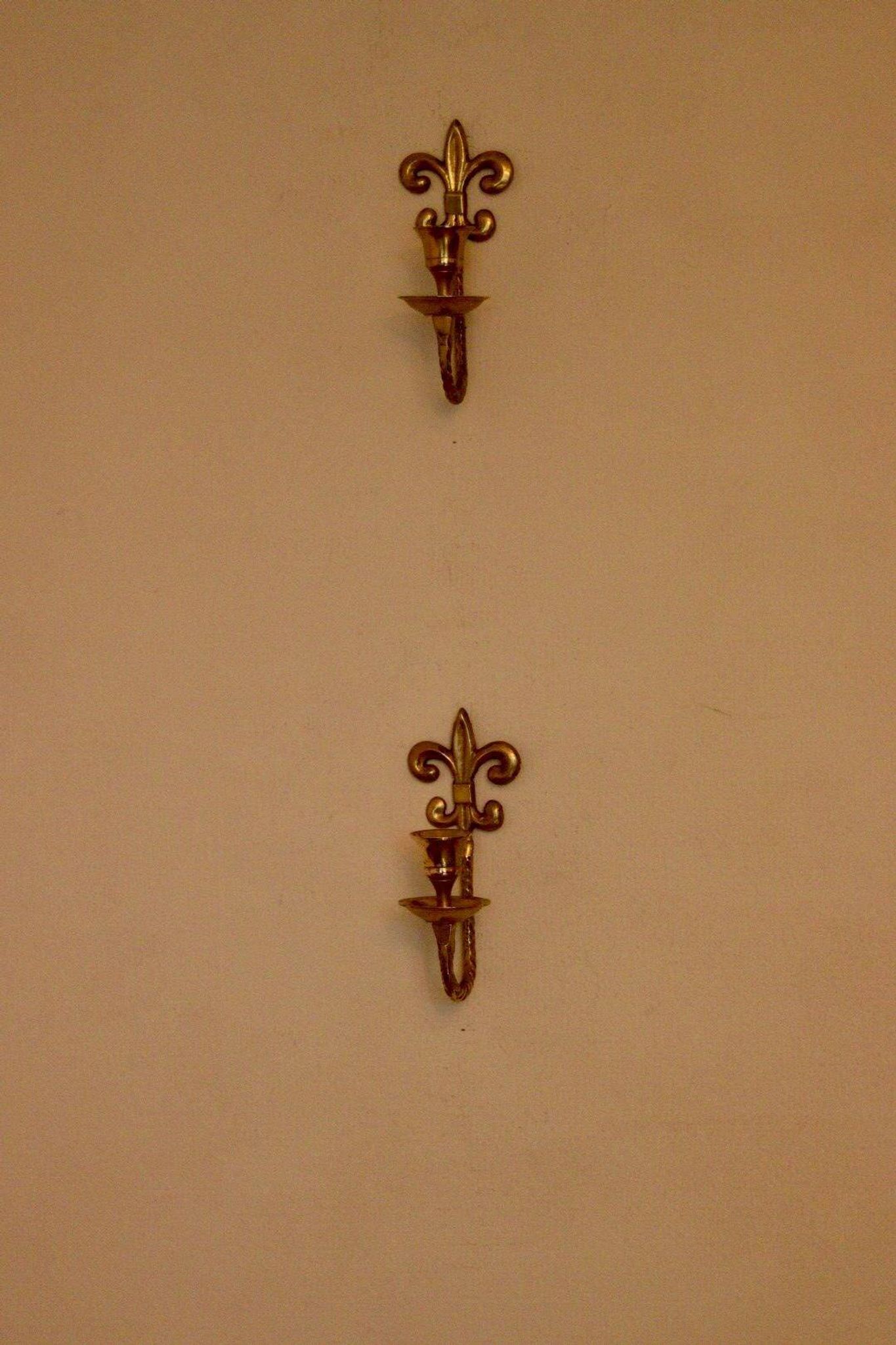 A pair of antique brass wall sconces.