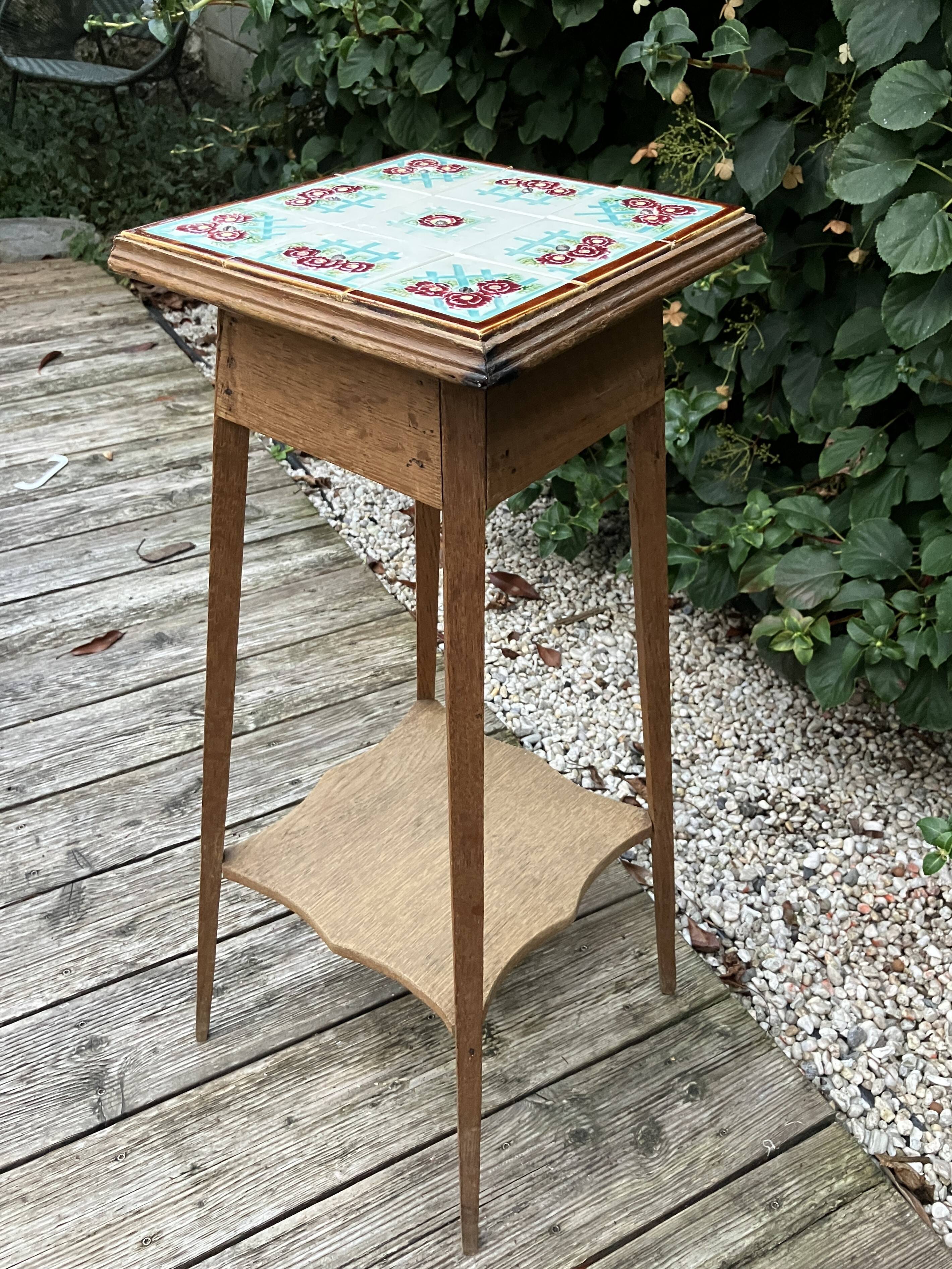 Antique wooden plant stand with ceramic tiles.