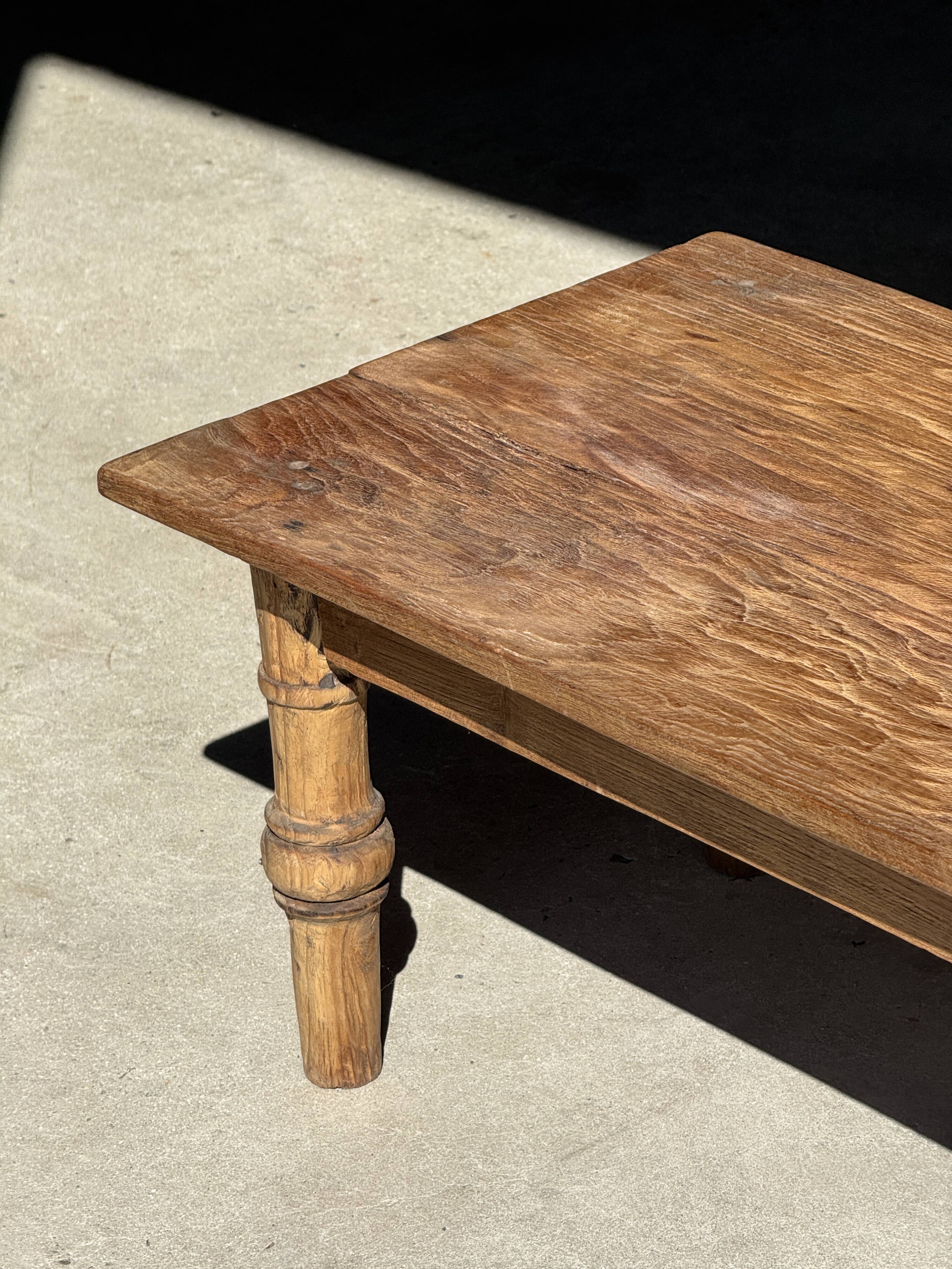 Brown Indonesian teak coffee table, with a border and cylindrical legs H40 L103.