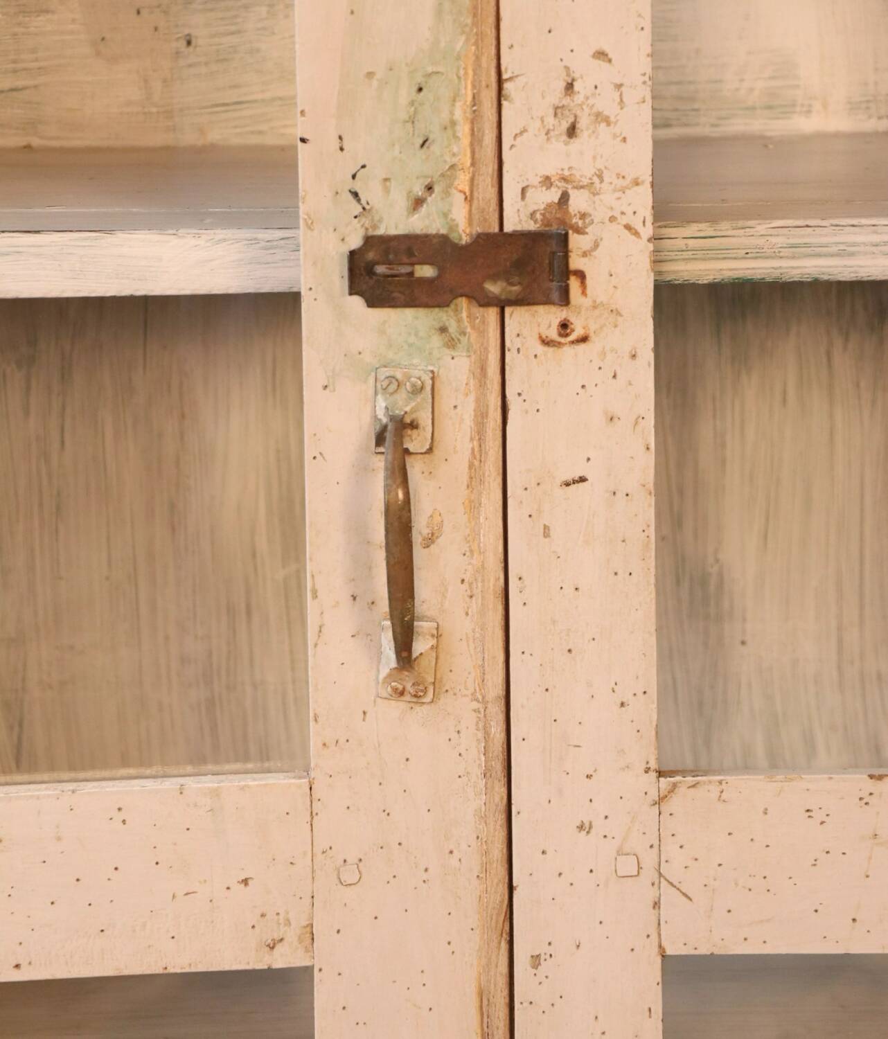 Teak display cabinet with a white-green patina.