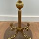 Guéridon rond de style néoclassique en laiton à piètement décoré de dauphins et plateau de celluloïde rouge cerclé d'une gallerie ajourée attribué à la Maison Jansen