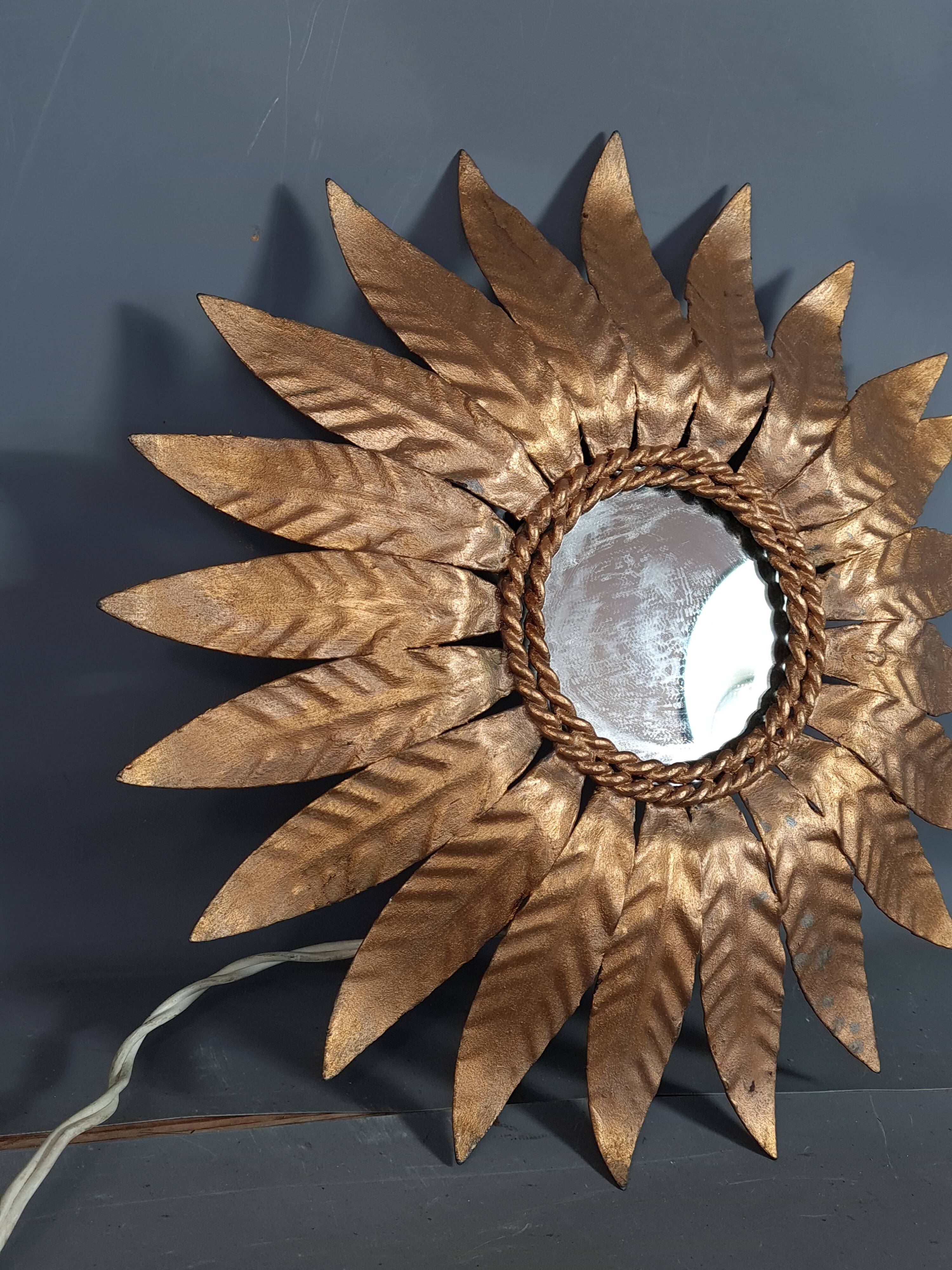 Wall lamp forming sun in gilded brass and with a mirror. Vintage 50s.