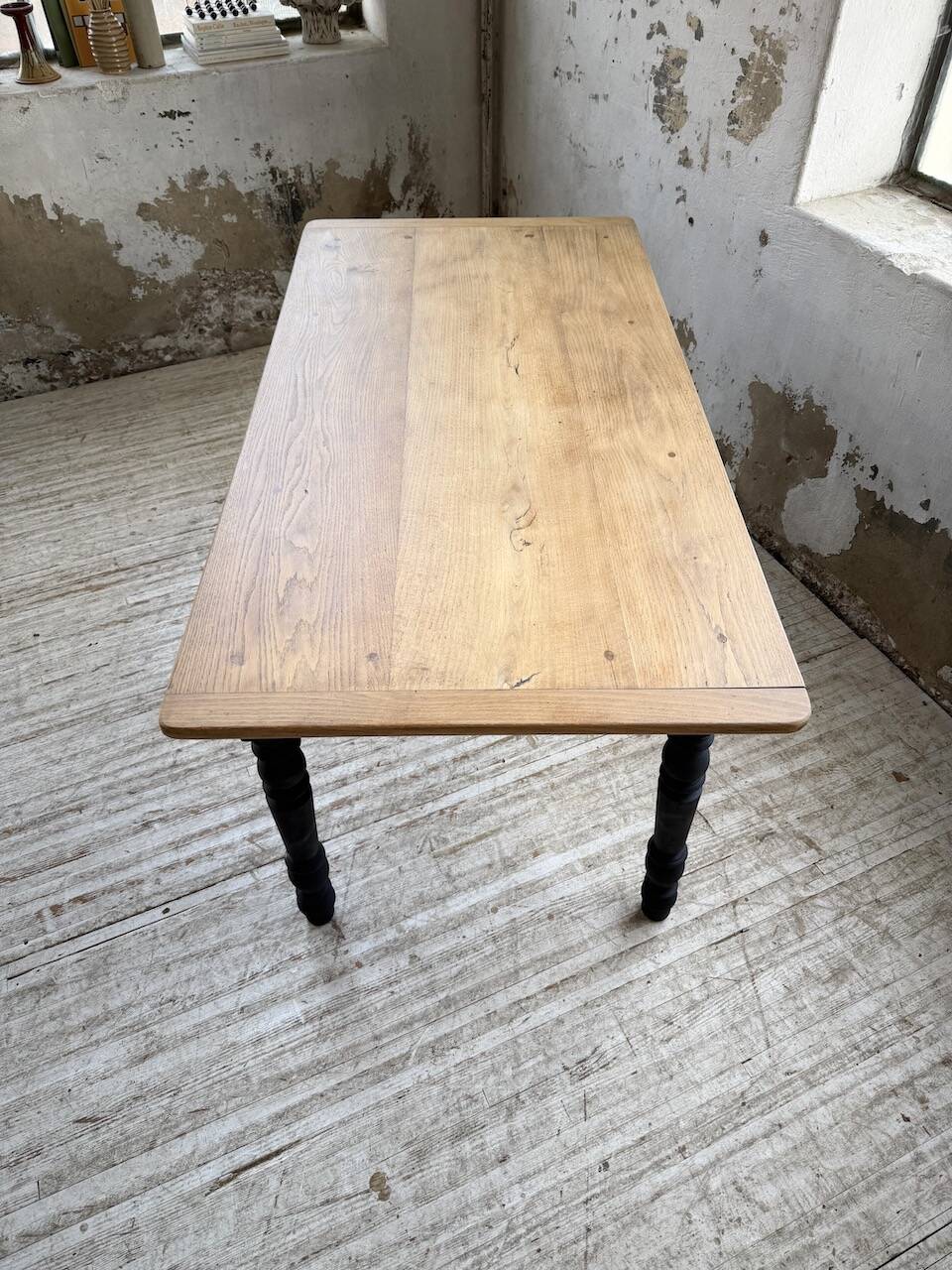 Oak farmhouse table with turned black legs.