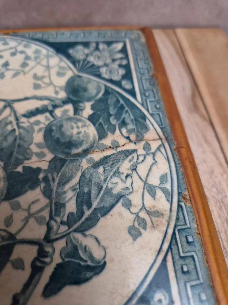 Antique trivet in Gien tile with blue bird decoration – wooden border